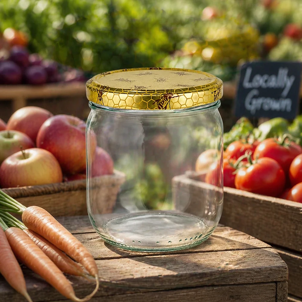 500g Honigglas mit Bienenwabe Deckel BasicSeal UNiTWIST Leeres 500g Honigglas mit Bienenwaben-Deckel auf Holzbrett zwischen frischem Gemüse vom Bauernmarkt