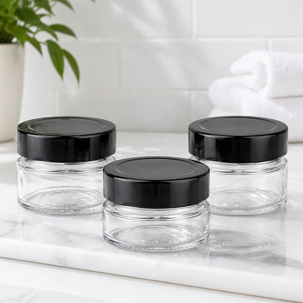80ml kulatá sklenice + víčko BasicSeal černé hluboké UNiTWIST Drei 80ml Rundgläser mit schwarzen BasicSeal Deckeln UNiTWIST auf weißer Marmorplatte Badezimmer Ambiente leer