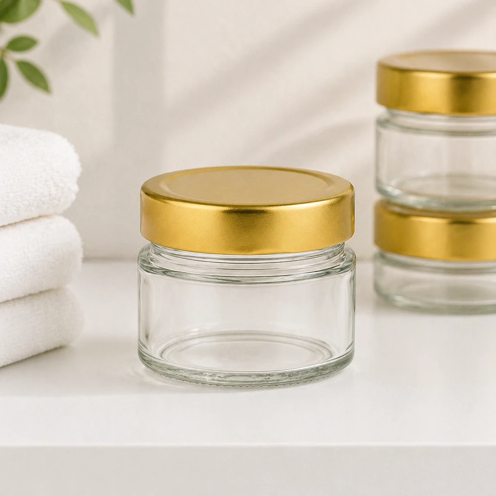 80ml kulatá sklenice s víčkem BasicSeal zlaté hluboké UNiTWIST. 80ml Rundglas mit BasicSeal Deckel gold deep im Badezimmer-Ambiente mit weißen Handtüchern für Kosmetik