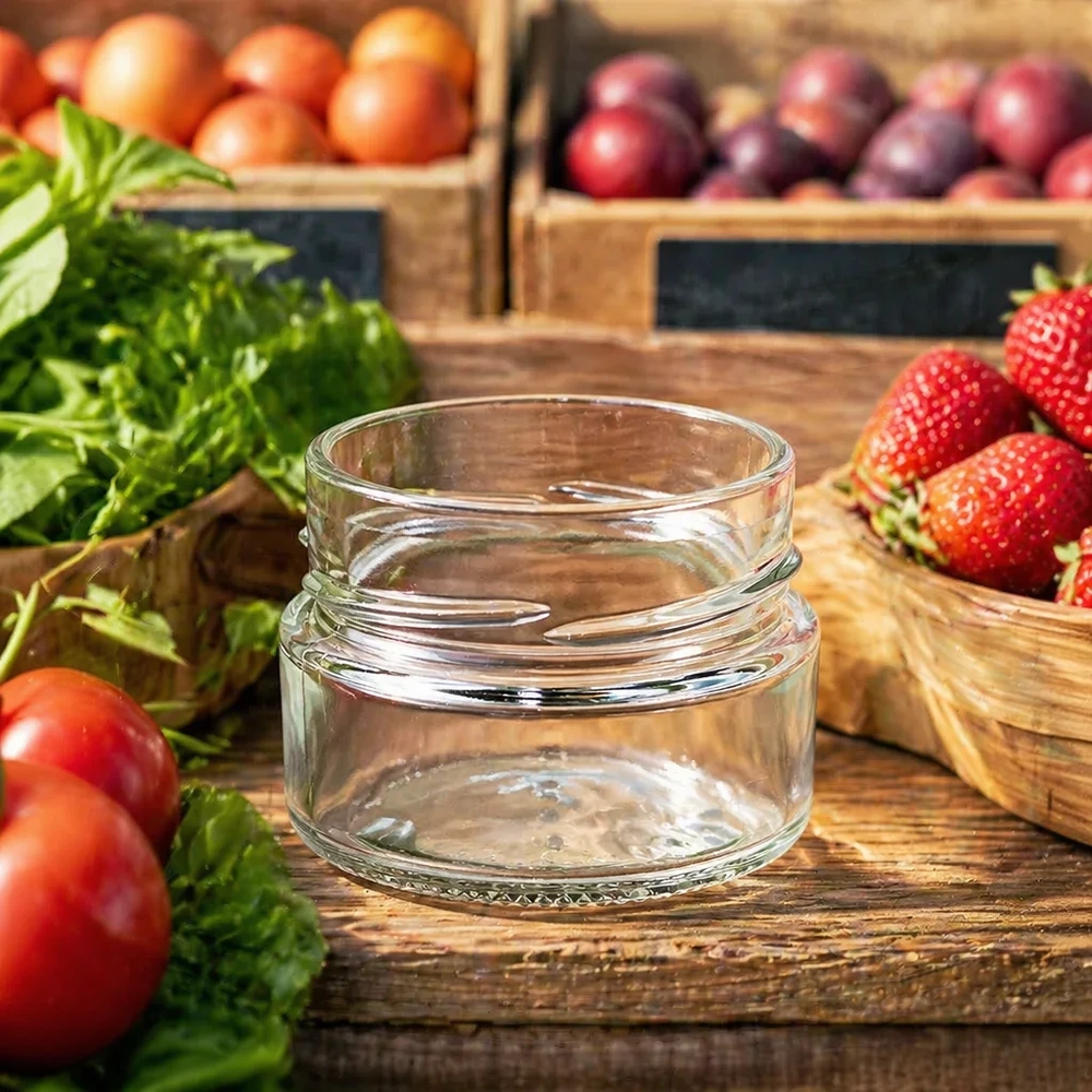 Kulatá sklenice o objemu 80 ml bez víčka (TO58deep) UNiTWIST UNiTWIST Runda80 Rundglas 80ml TO58deep leeres Einmachglas auf Holztisch mit frischem Obst und Gemüse im Hintergrund