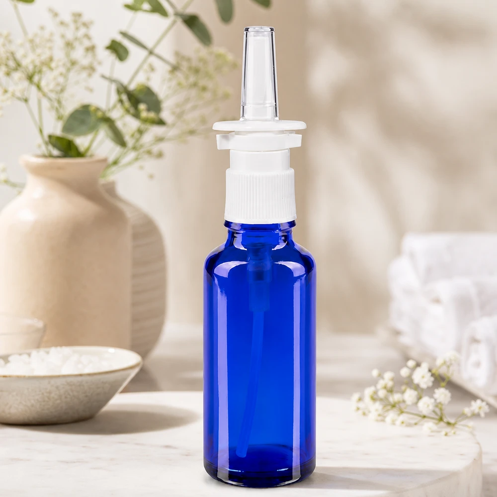 Lékárenská lahvička modrá 30ml nosní rozprašovač bílá standardní Seitenansicht blaue Pharmaflasche 30ml mit weißem Nasalsprayer auf hellem Marmoruntergrund