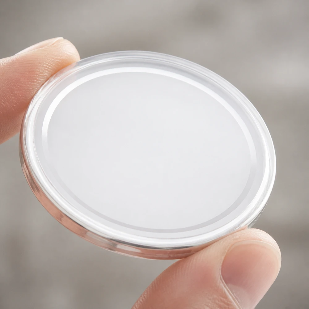 Detailní záběr na bílé víčko BasicSeal 82 mm TO82 UNiTWIST držené mezi palcem a ukazováčkem