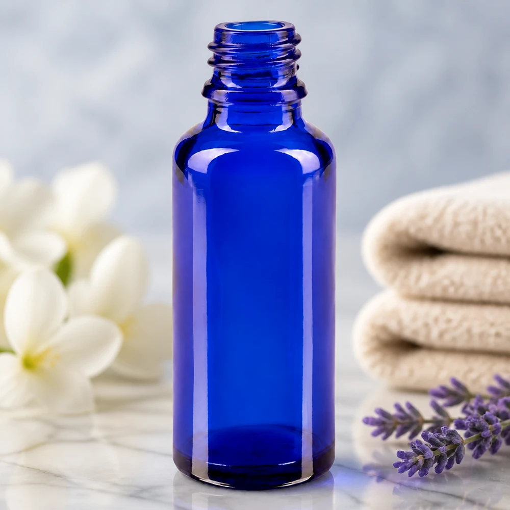 Lahvička s kapátkem 30ml DIN 18 BLAUGLAS ApoGlas 30ml Flasche in Blau umgeben von Spa-Accessoires Lavendel und Jasminblüten