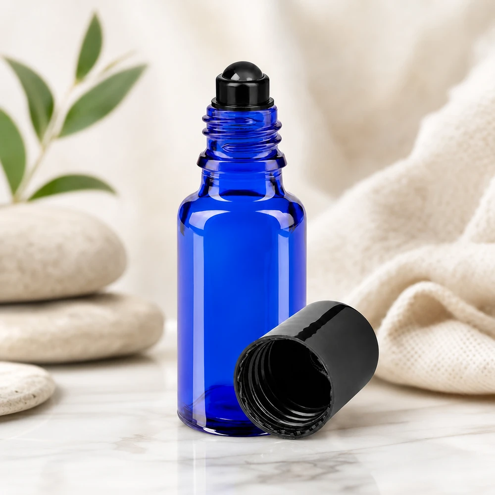 Roll-On Flasche 20ml Blauglas STD schwarze Kappe neben Natursteinen und Textil