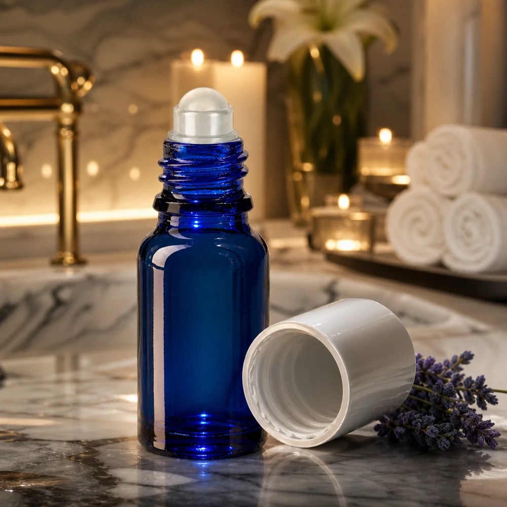 Lékárenská lahvička modrá 10ml roll-on uzávěr bílý Kobaltblaue 10ml Rollerflasche mit abgenommenem weißen Deckel vor Kerzen und Handtüchern