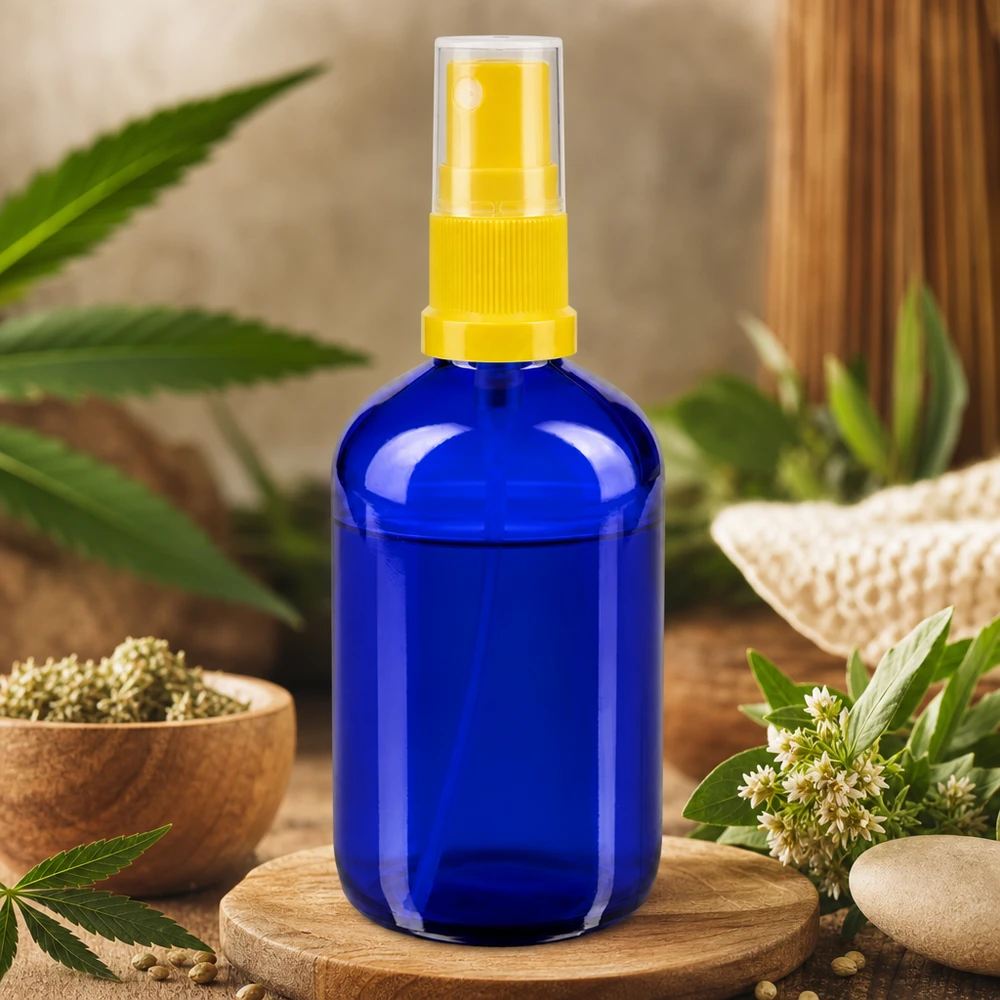 100ml blaue Rundglasflasche mit gelbem Sprühaufsatz im natürlichen Kräuter-Ambiente