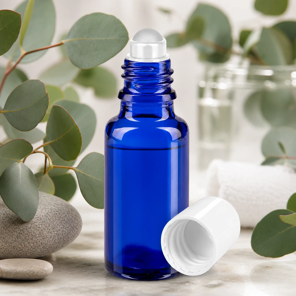 Lékárenská lahvička modrá 20ml roll-on uzávěr bílý Roll-On Flasche 20ml kobaltblau mit weißem Deckel umgeben von Eukalyptus und Spa-Elementen