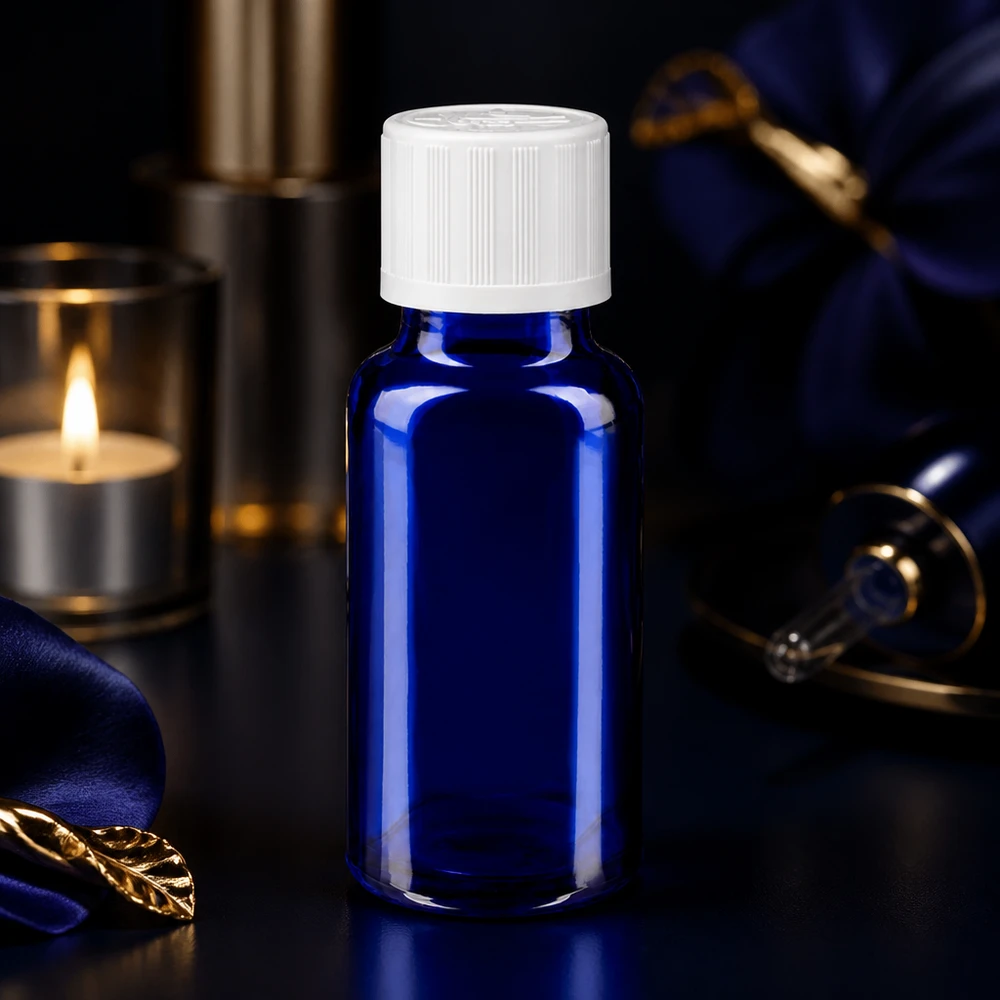 Apothekerglasflasche 20ml blau mit weißem Verschluss neben Kerze und Seidenstoff