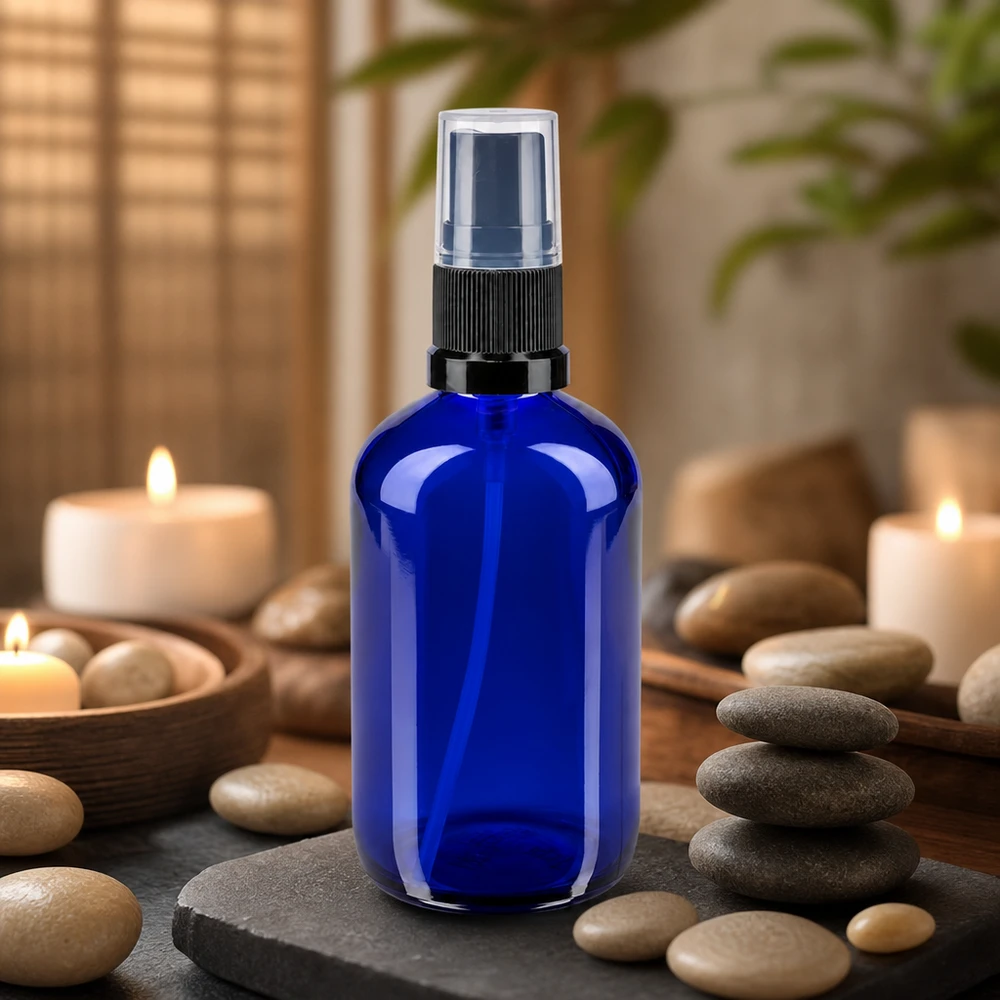 Zylindrische 100ml Apotheker Sprühflasche in Kobaltblau mit schwarzem Zerstäuber im Wellness Setting