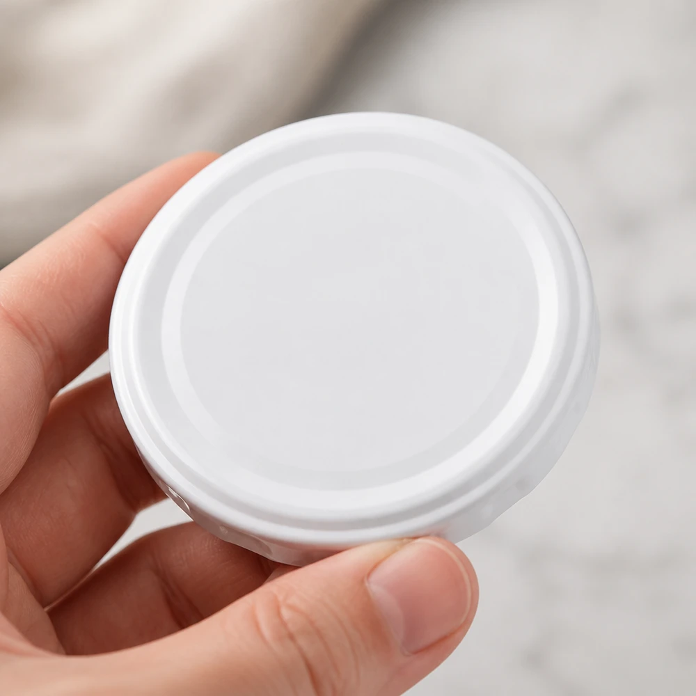 58mm víko BasicSeal bílé (TO58deep) UNiTWIST Pohled shora na bílé víčko TO58deep 58 mm BasicSeal UNiTWIST, kulatý tvar, rovnoměrný povrch