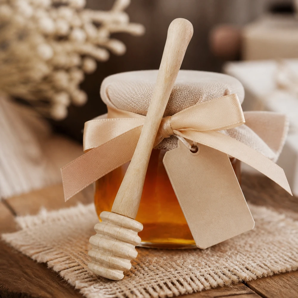 Honiglöffel Ahornholz mit Geschenkverpackung und Band als Präsent neben Honigwaben auf Jute-Untergrund