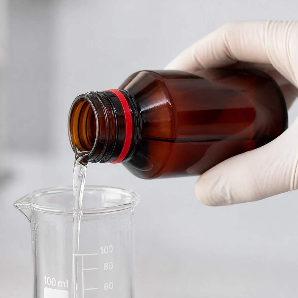 PET láhev 50ml s bílým/červeným uzávěrem s možností manipulace. Laborant naplňuje hnědou PET láhev o objemu 50 ml čirou kapalinou z zkumavky