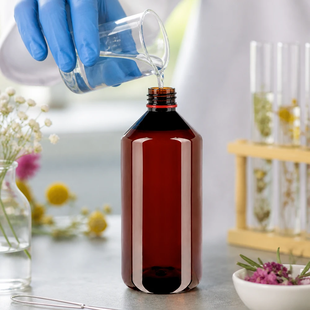 Jantarově zbarvená plastová láhev o objemu 1000 ml se v laboratoři naplňuje kapalinou; modré ochranné rukavice