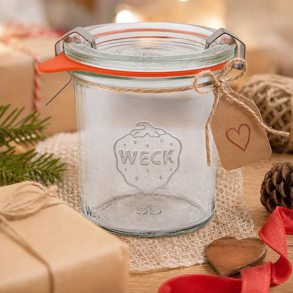 Kompletní 140ml sklenice se svěžestí WECK RR60 WECK Sturzglas 140ml RR60 als Geschenkidee dekoriert mit Herzanhänger und Juteschnur auf Holztisch mit Tannenzapfen