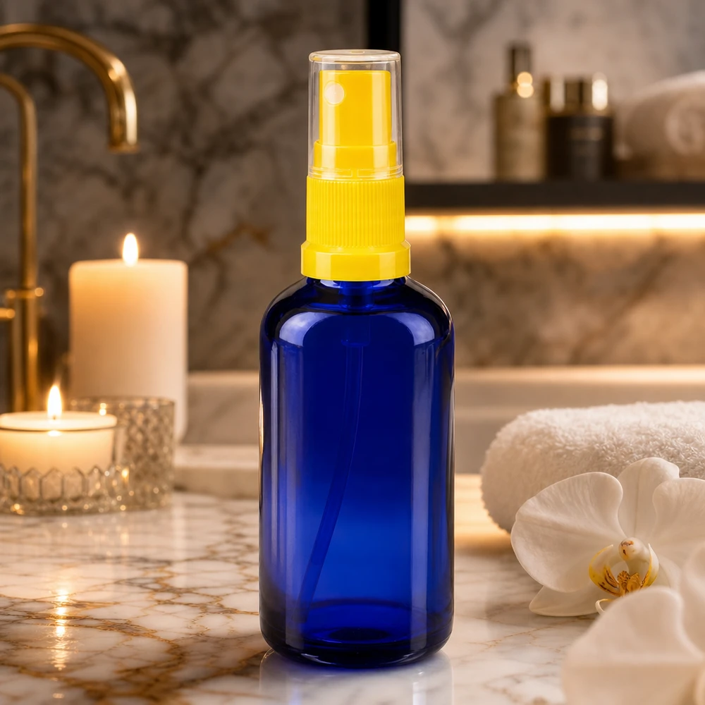 Lékárenská lahvička modrá 50ml s rozprašovacím víčkem žlutá 50ml Blauglasflasche mit gelbem Feinnebel-Zerstäuber auf goldenem Marmorwaschtisch
